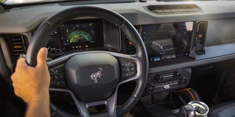 A view of the steering wheel and drivers side interior on a 2024 Ford Bronco